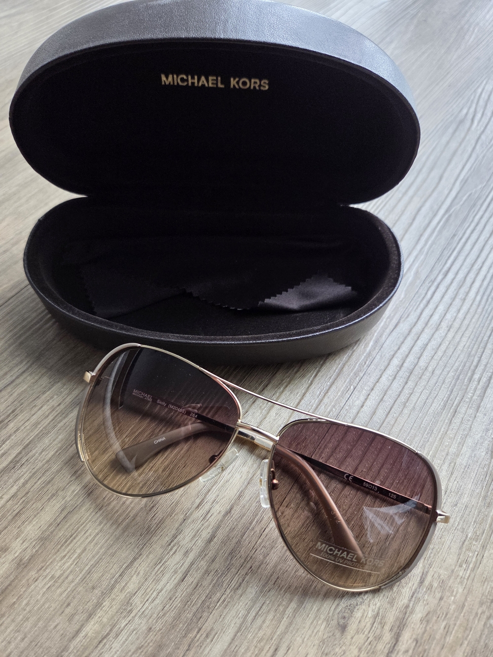 Michael Kors Sicily M2045S in Brown features a signature aviator silhouette